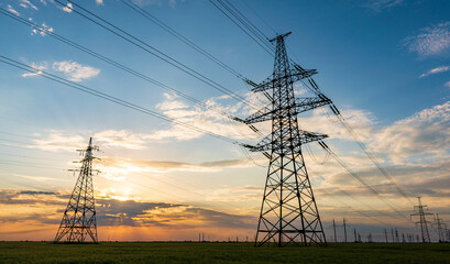 Wall Mural - silhouette of high voltage power lines against a colorful sky at sunrise.
