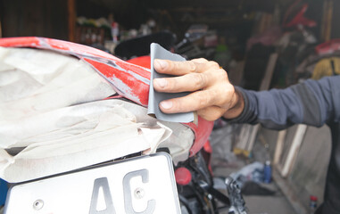 Wall Mural - Preparation for painting a motorcycle. Hand in a sandpaper