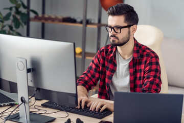 Portrait of attractive trendy skilled focused guy writing code web start-up project development at office work place station indoor