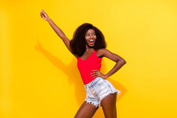 Wall Mural - Portrait of attractive cheerful girl having fun rest dancing free time weekend isolated over bright yellow color background