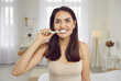 © Studio Romantic - Charming woman with dazzling smile brushing her teeth the right way. Happy young Caucasian lady looking at camera while cleaning front teeth with whitening toothpaste and plastic toothbrush in morning