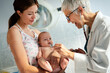 © NDABCREATIVITY - Mother holding baby for pediatrician doctor to examine