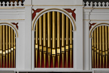 The Front Of An Vintage Pipe Organ With Pipes Being In Gold Color