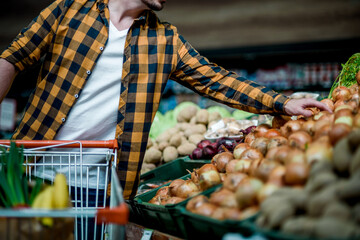 Wall Mural - Young handsome man in a supermarket grocery shopping