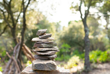 Stack Of Stones Against Green Trees In Woods