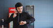 © eakgrungenerd - handsome businessman looking wristwatch and talking telephone checking work time.
