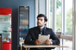 © eakgrungenerd - handsome businessman holding tablet at cafe.