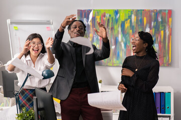 Wall Mural - Happy, joyful, satisfied employees of corporations of different nationalities, skin color laugh, enjoy tossing documents, cards, reports up in the air dismissed from disliked job, leave the company