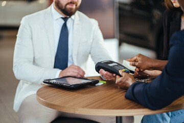 Poster - Male customer using credit card for payment at auto salon