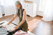© Drobot Dean - Mature asian woman with grey hair packing suitcase at home