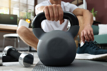 Poster - Man with kettlebell on floor at home, closeup