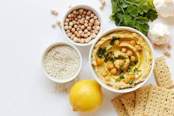 Wall Mural - Hummus - chickpea traditional jewish and lebanese cuisine meal on white background, flat lay, from above overhead top view, closeup, houmous is a vegan healthy legume food