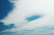 Background. Blue sky with beautiful light airy clouds like feathers. High. Desktop wallpaper. Nice, natural. Nature. Freedom. Stripes of oblates float across the endless sky.