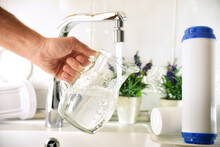 Hand filling jug from a tap with filtered osmosis water