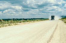 Industrial Dump Truck, Transportation Of Stones, Rides On A Dusty Road. Career Work.Cloudy Sky