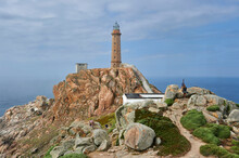 The Tower And Lantern Of The Cape Vilán Lighthouse Seen From The Rocks Of The Mountain With Tourists Around