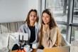 © Andrii - Two young beautiful girls are sitting in a cafe, recording video blogs and communicating on social networks.