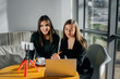 © Andrii - Two young beautiful girls are sitting in a cafe, recording video blogs and communicating on social networks.