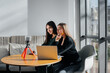 © Andrii - Two young beautiful girls are sitting in a cafe, recording video blogs and communicating on social networks.