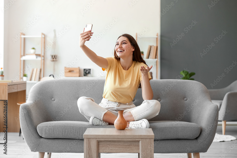 Young woman in great mood taking selfie at home