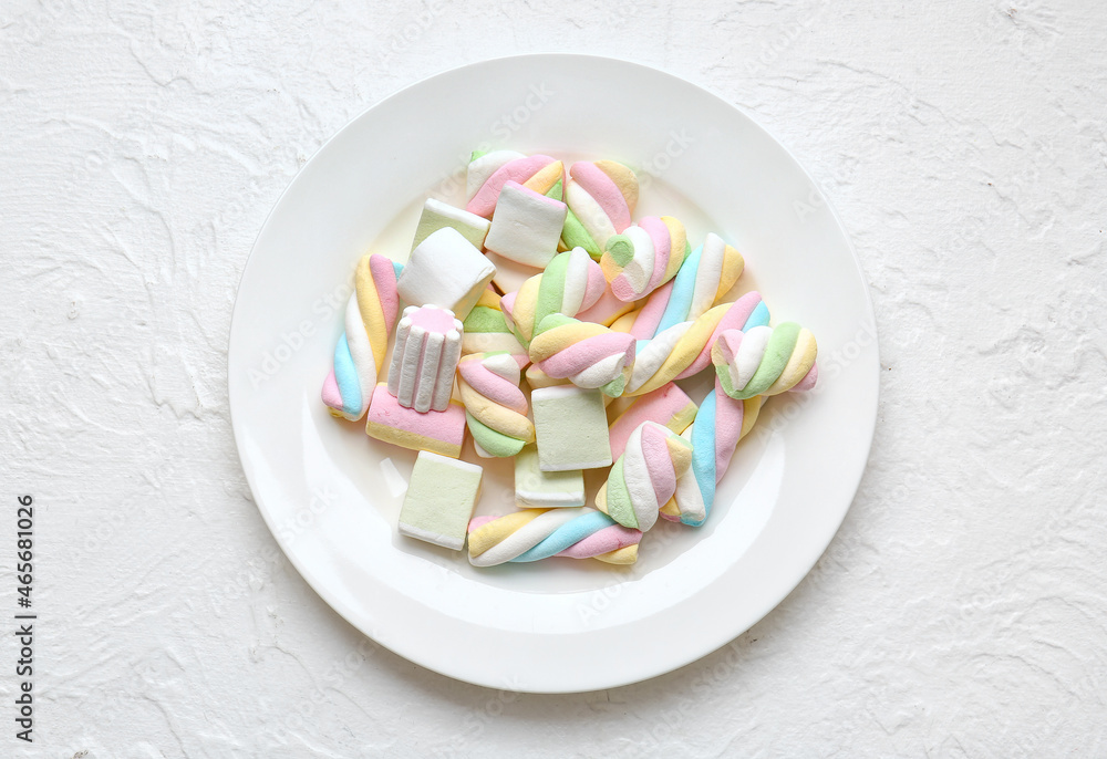 Plate with tasty colorful marshmallows on light background