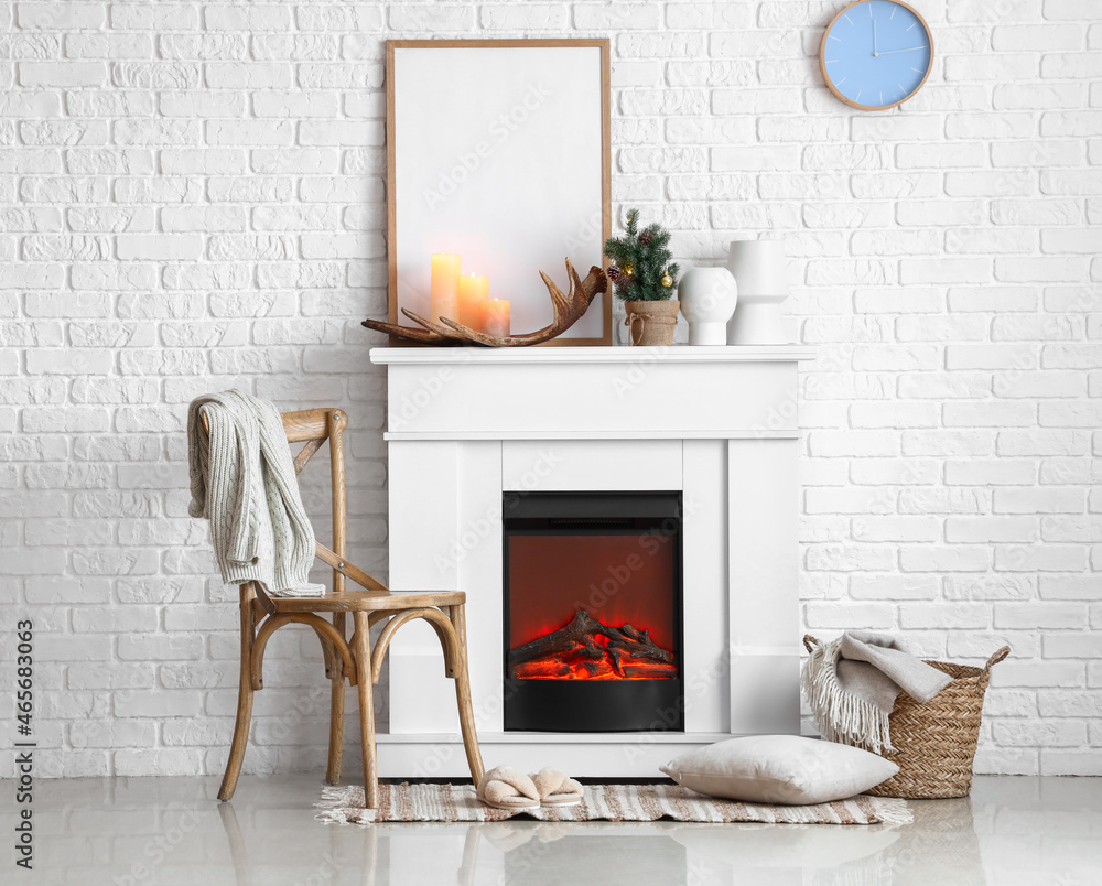 Interior of light room with electric fireplace and small Christmas tree