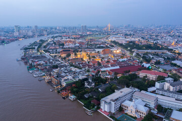 Aerial view Day to Night of Chao Phraya River with Royal Grand Palace and Emerald Buddha Temple Landmark of Bangkok, Thailand. Amazing Drone Footage over the City skyline in twilight.