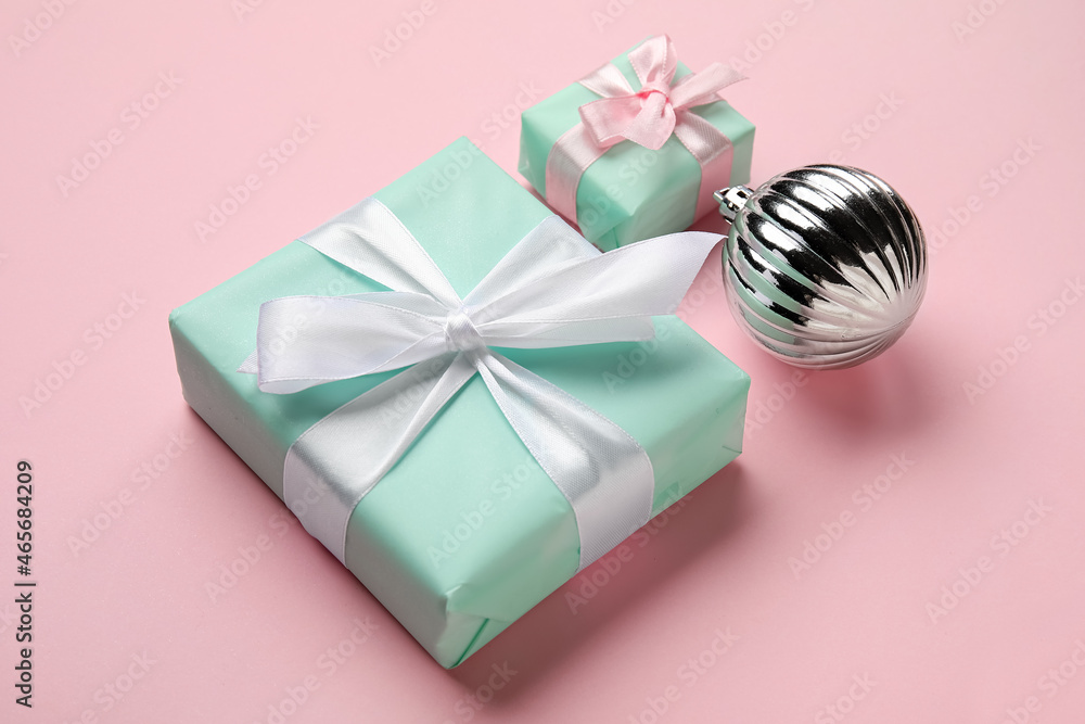 Gift boxes and Christmas ball on pink background