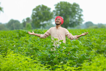 Poster - Young indian farmer at green agriculture field.