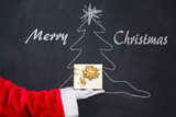 Fototapeta  - Christmas gift from Santa Claus.Christmas holiday background on blackboard