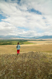 Fototapeta Kuchnia - The girl in a picturesque place looks at the mountains and the steppe