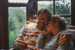Couple celebrate alone at home with smile and fire sparkler sitting on the couch qieh outdoor nature view. Happy caucasian people in love and friendship enjoy celebration. Focus on sparkler