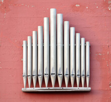 Silver Pipe Organ On A Red Wall