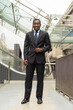 Full length portrait of handsome African businessman in city