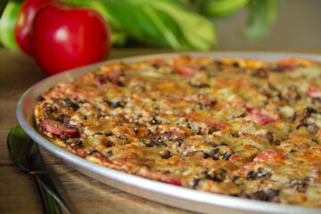 Wall Mural - Closeup shot of a gourmet meat pizza in  thin-crust flatbread style