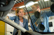 female apprentice mechanic changing windscreen on car