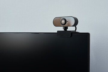 Webcam above computer screen. Black webcam above black screen. Digital security concept