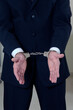 © gal - handcuffs on the hands of a businessman during arrest