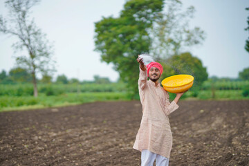 Sticker - Indian farmer spreading fertilizer in the agriculture field.