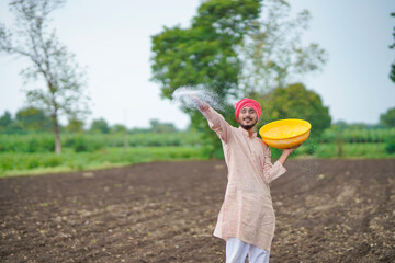 Sticker - Indian farmer spreading fertilizer in the agriculture field.