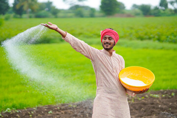 Sticker - Indian farmer spreading fertilizer in the agriculture field.