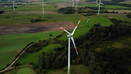 Poster - A 4K video of multiple wind turbines with red edges spinning in a wide rural field