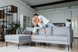 © LIGHTFIELD STUDIOS - cheerful young couple having fun in modern living room