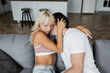 © LIGHTFIELD STUDIOS - young man kissing neck of blonde woman with closed eyes in living room