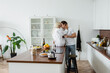 © LIGHTFIELD STUDIOS - young couple with glasses of wine hugging in modern kitchen