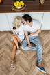 © LIGHTFIELD STUDIOS - top view of young couple holding glasses of wine while sitting on kitchen floor