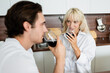 © LIGHTFIELD STUDIOS - blonde woman drinking red wine and looking at blurred boyfriend