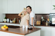 © LIGHTFIELD STUDIOS - happy woman adjusting blonde hair near boyfriend in kitchen