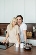 © LIGHTFIELD STUDIOS - young couple looking at camera in modern kitchen