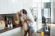 © LIGHTFIELD STUDIOS - happy woman feeding boyfriend with croissant while having fun in kitchen